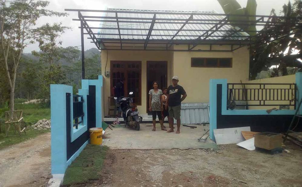 Lahuri dan keluarganya di depan rumah hasil bantuan bedah rumah korban bencana di Pacitan