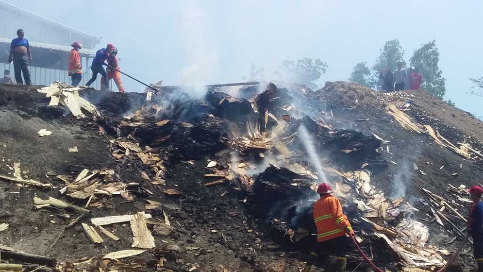 Personel pemadam kebakaran Pacitan memadamkan api yang hampir membakar Triplek Temon Raya Minggu (09/08/2018)