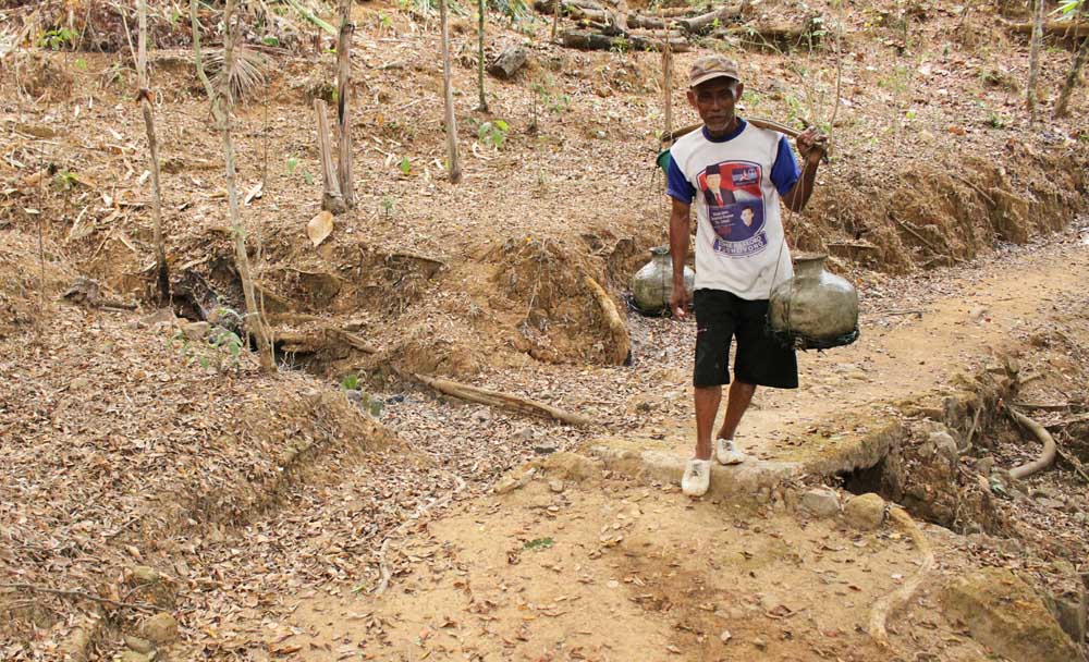 Seorang warga Dusun Pagergunung, Desa Sambong Kecamatan Pacitan, mengambil dari sumber air tersisa yang ada di wilayahnya (19/10/2018).