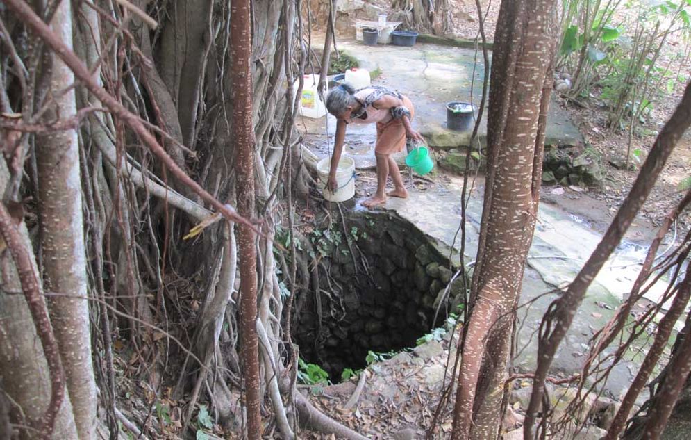 Seorang warga mengambil air di sumur tua Dusun Pagergunung