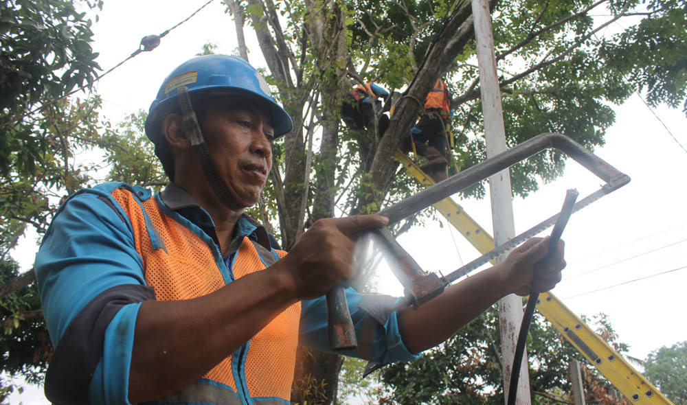 Petugas teknisi PLN membenahi kabel di salah satu ruas jalan di Pacitan.