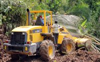 Wheel loader Dinas PUPR Kabupaten Pacitan mencoba menyingkirkan batu besar yang menutupi jalan