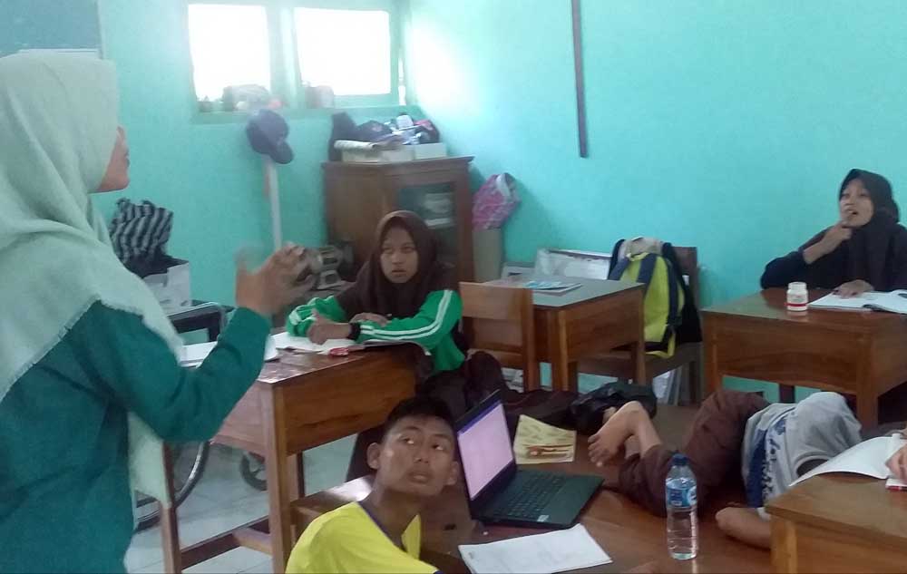 Hersen Nehrulita (berdiri) sedang mengajar pengenalan kata pada anak-anak tuna rungu