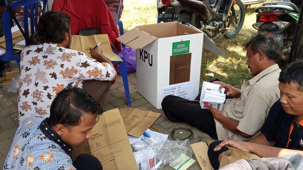 Anggota KPPS memeriksa logistik pemilu yang akan digunakan di TPS mereka