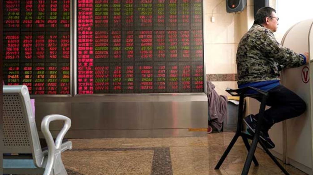 <p>Seorang investor duduk di sebelah papan harga di bursa saham Beijing/Reuters</p>
