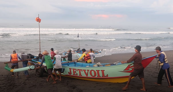 Nelayan di Pantai Depok sedang bersiap untuk melaut dengan dibantu para pendorong.