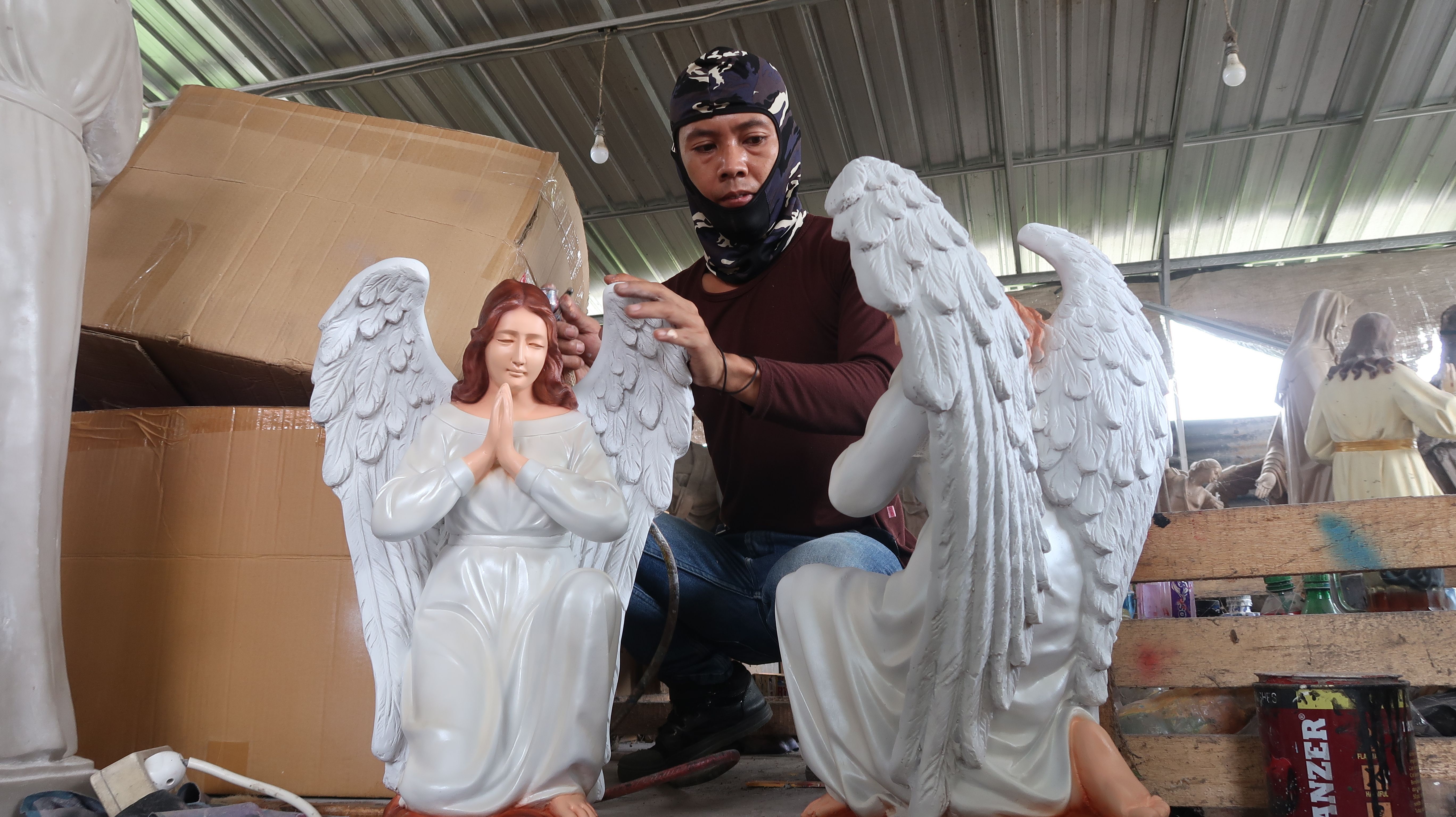 Pekerja tengah mengecat patung rohani di tempat produksi Malta Jaya Art.