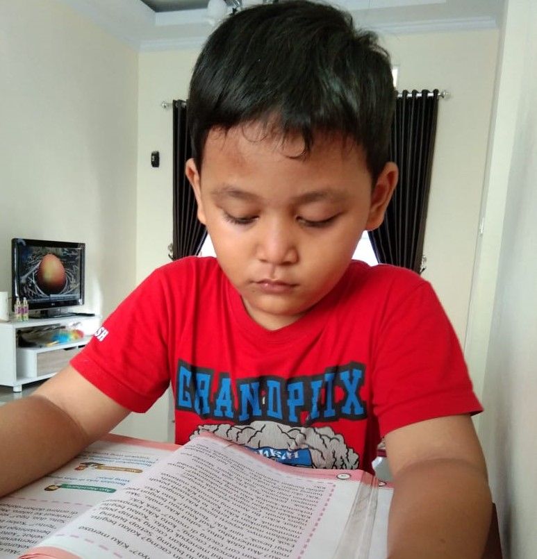 Seorang siswa SD Pangudi Luhur Yogyakarta bernama Jovan sedang belajar di rumah.