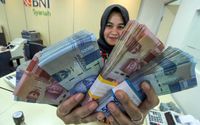 <p>Petugas bank menunjukkan uang saat melayani penarikan uang nasabah di bank BNI Syariah Lhokseumawe, Aceh, Jumat (13/3/2020).  Gubernur Bank Indonesia menyebutkan nilai tukar Rupiah terhadap Dolar Amerika Serikat kembali melemah di Rp14.640 per dolar AS atau sebesar 0,81% pada perdagangan pasar spot, Jumat (13/3) pagi, dampak sentimen kekhawatiran pelaku pasar keuangan terhadap virus Corona (COVID-19). ANTARA FOTO/Rahmad/ama.</p>
