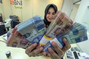 <p>Petugas bank menunjukkan uang saat melayani penarikan uang nasabah di bank BNI Syariah Lhokseumawe, Aceh, Jumat (13/3/2020). Gubernur Bank Indonesia menyebutkan nilai tukar Rupiah terhadap Dolar Amerika Serikat kembali melemah di Rp14.640 per dolar AS atau sebesar 0,81% pada perdagangan pasar spot, Jumat (13/3) pagi, dampak sentimen kekhawatiran pelaku pasar keuangan terhadap virus Corona (COVID-19). ANTARA FOTO/Rahmad/ama.</p>