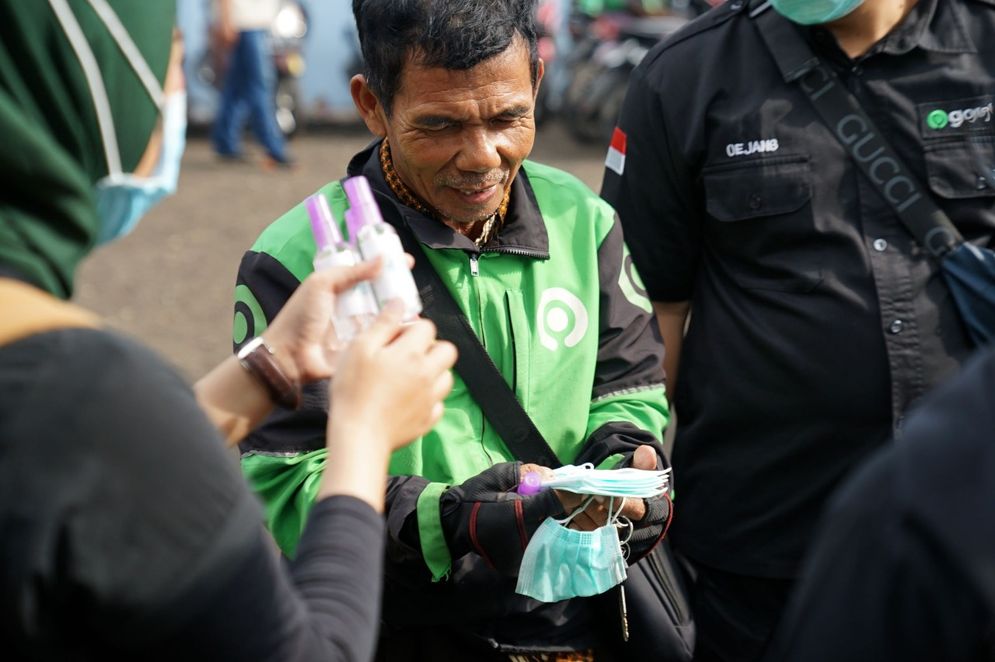 Mitra driver Gojek saat menerima bantuan masker, hand sanitizer, dan vitamin C.