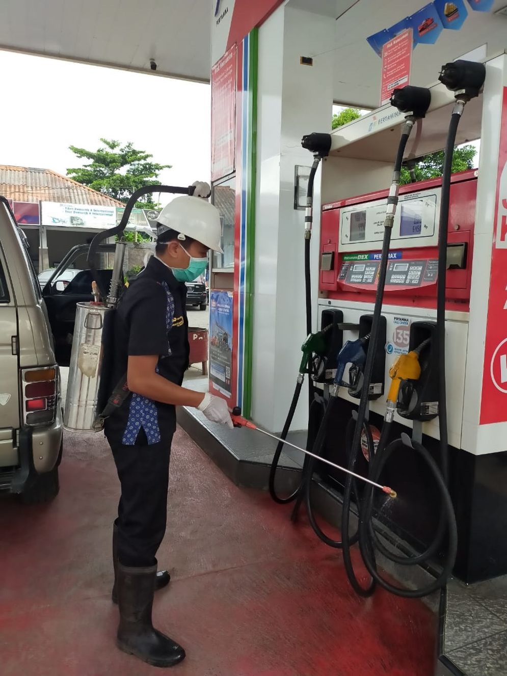 Petugas SPBU melakukan penyemprotan cairan untuk menghindari penyebaran Covid-19 di semua sudut yang disentuh banyak orang. 
