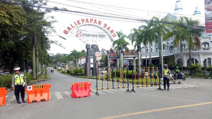 Petugas kepolisian menjaga jalan kota yang ditutup sementara di Kota Balikpapan
