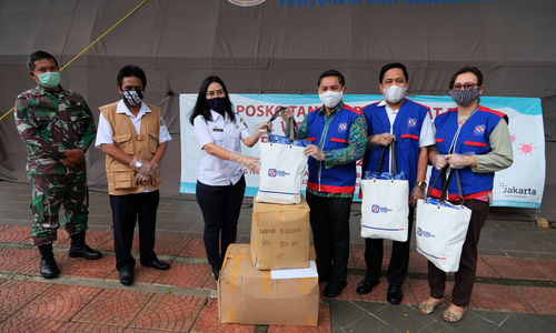 <p>Vice President Human Resources APL Group Hidayat Bakri (ketiga kanan) beserta rombangan menyerahkan paket bantuan kepada perwakilan tim Posko Tanggap Darurat penanggulangan Bencana Wabah COVID-19 Provinsi DKI Jakarta, Marulina Dewi (ketiga kiri) di Posko BPBD Balaikota, Jakarta, Rabu 29 April 2020. Yayasan Agung Podomoro Land (APL) memberikan bantuan berupa 250 alat pelindung diri (APD) dan 1000 masker untuk penanggulangan wabah COVID-19 di Jakarta. Foto: Ismail Pohan/TrenAsia</p>
