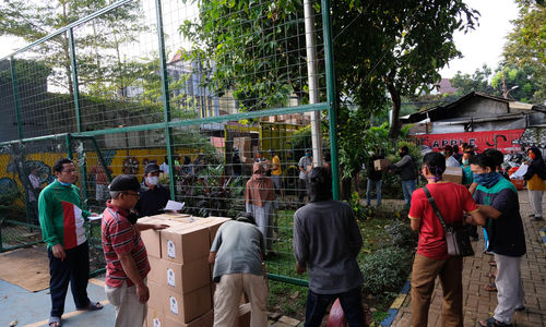 <p>Warga bergotong-royong menurunkan paket sembako yang akan di bagikan kepada warga RW.04 Kelurahan Jatipadang, Pasar Minggu saat tiba di RPTRA Asoka, Jakarta Selatan, Rabu (22/4/2020). Kementerian Sosial bersama Pemprov DKI Jakarta dan PD Pasar Jaya menyalurkan 5023 paket sembako untuk warga Kelurahan Jatipadang, Jakarta Selatan yang terdampak COVID-19. Foto: Ismail Pohan/TrenAsia</p>
