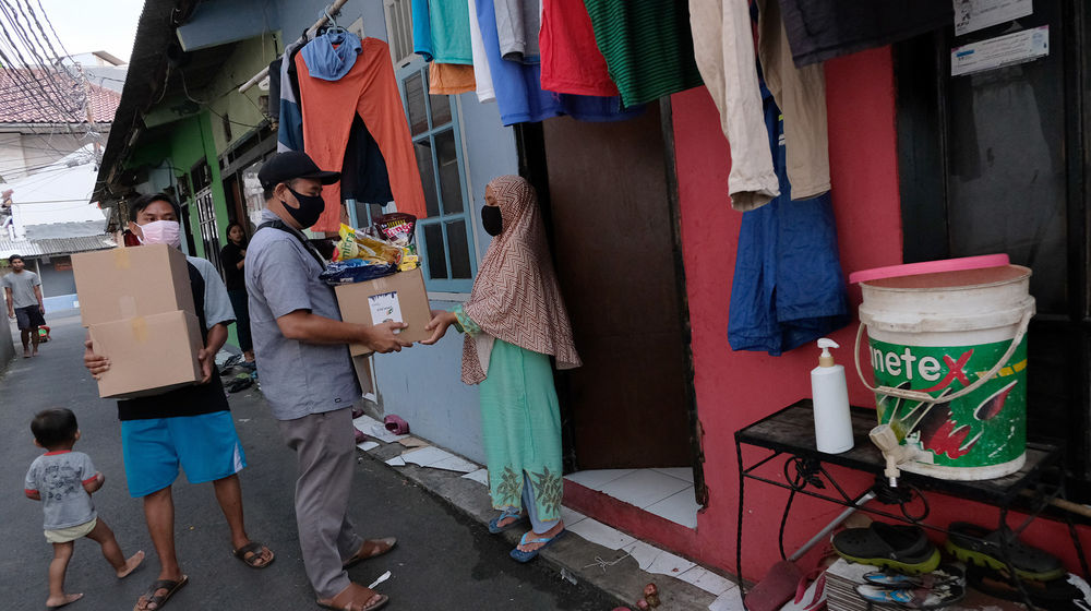 <p>Pejabat RT setempat memberikan paket sembako kepada warga RW.04 Kelurahan Jatipadang, Pasar Minggu, Jakarta Selatan,  Rabu (22/4/2020). Kementerian Sosial bersama Pemprov DKI Jakarta dan PD Pasar Jaya menyalurkan 5023 paket sembako untuk warga Kelurahan Jatipadang, Jakarta Selatan yang terdampak COVID-19. Foto: Ismail Pohan/TrenAsia</p>
