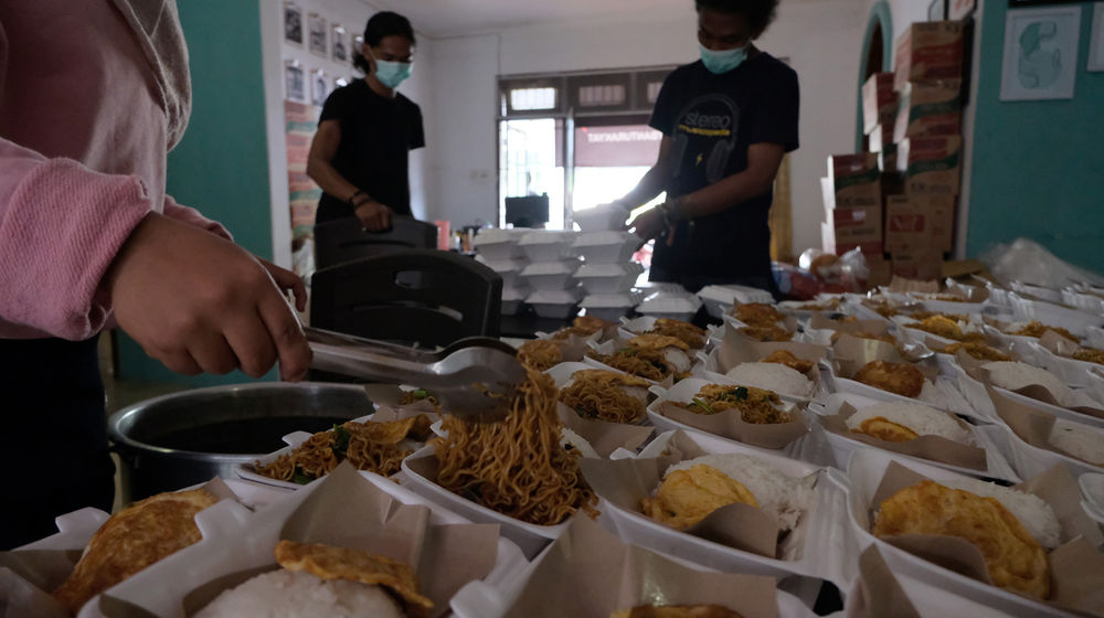 <p>Sejumlah relawan menyiapkan porsi makanan siap saji di kafe yang dirubah menjadi dapur umum bernama “Dapur Untuk Rakyat” di kawasan Pisangan, Ciputat, Tangerang Selatan, Banten, Senin (20/4/2020). Sekelompok pemuda dari berbagai latar belakang mengubah sebuah cafe yang terdampak COVID-19 menjadi dapur umum dan digunakan untuk memasak makanan siap saji yang akan dibagikan kepada warga yang membutuhkan. Bahan makanan didapat dari sumbangan para donatur yang sudah dimulai sejak 8 April lalu dan akan terus berlangsung hingga pandemi berakhir sebagai bentuk kepedulian terhadap dampak COVID-19. Foto: Ismail Pohan/TrenAsia</p>

