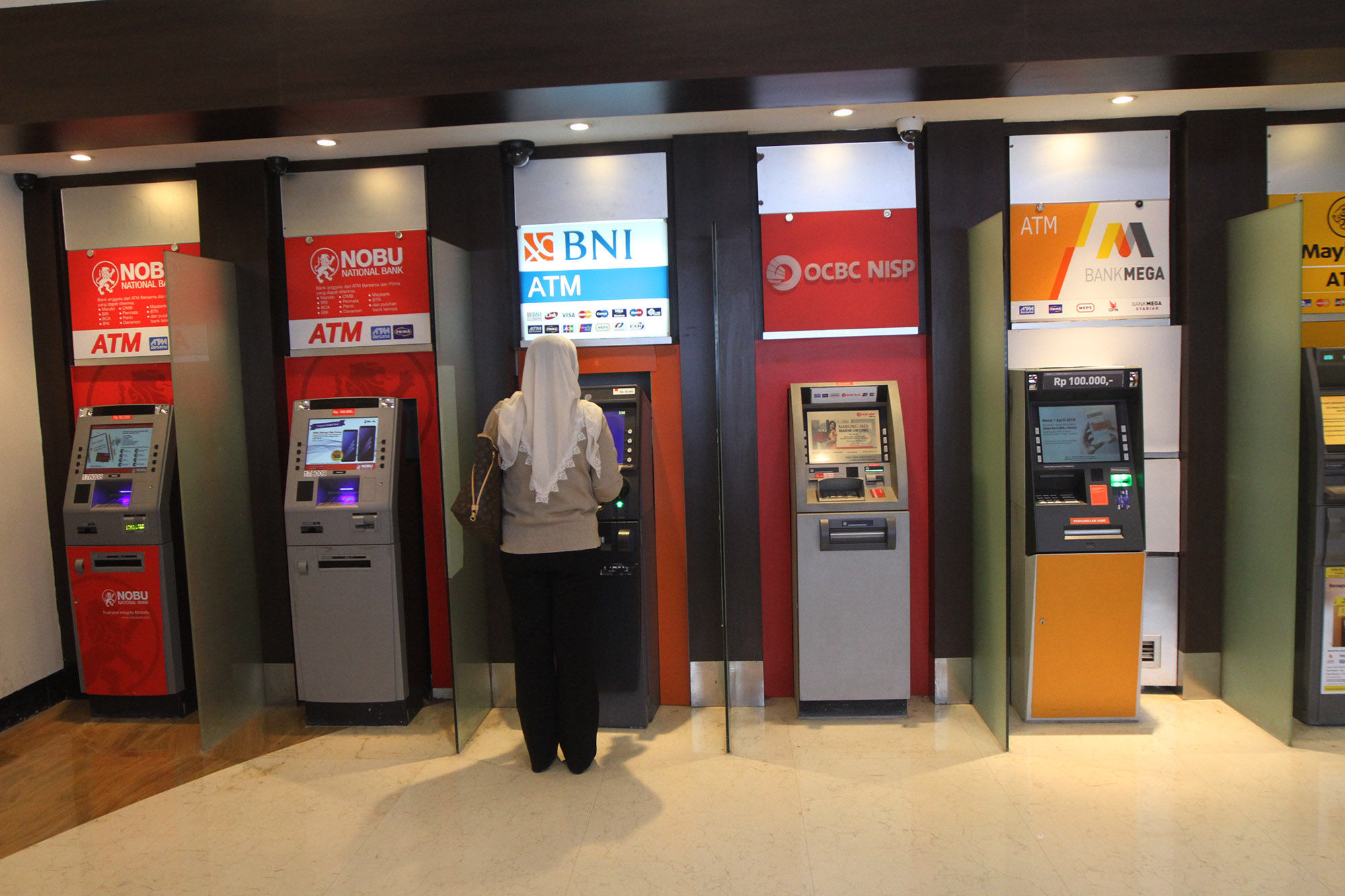 <p>Warga menggunakan fasilitas anjungan tunai mandiri (ATM) di salah satu pusat perbelanjaan di Jakarta. foto: Ismail Pohan/TrenAsia</p>
