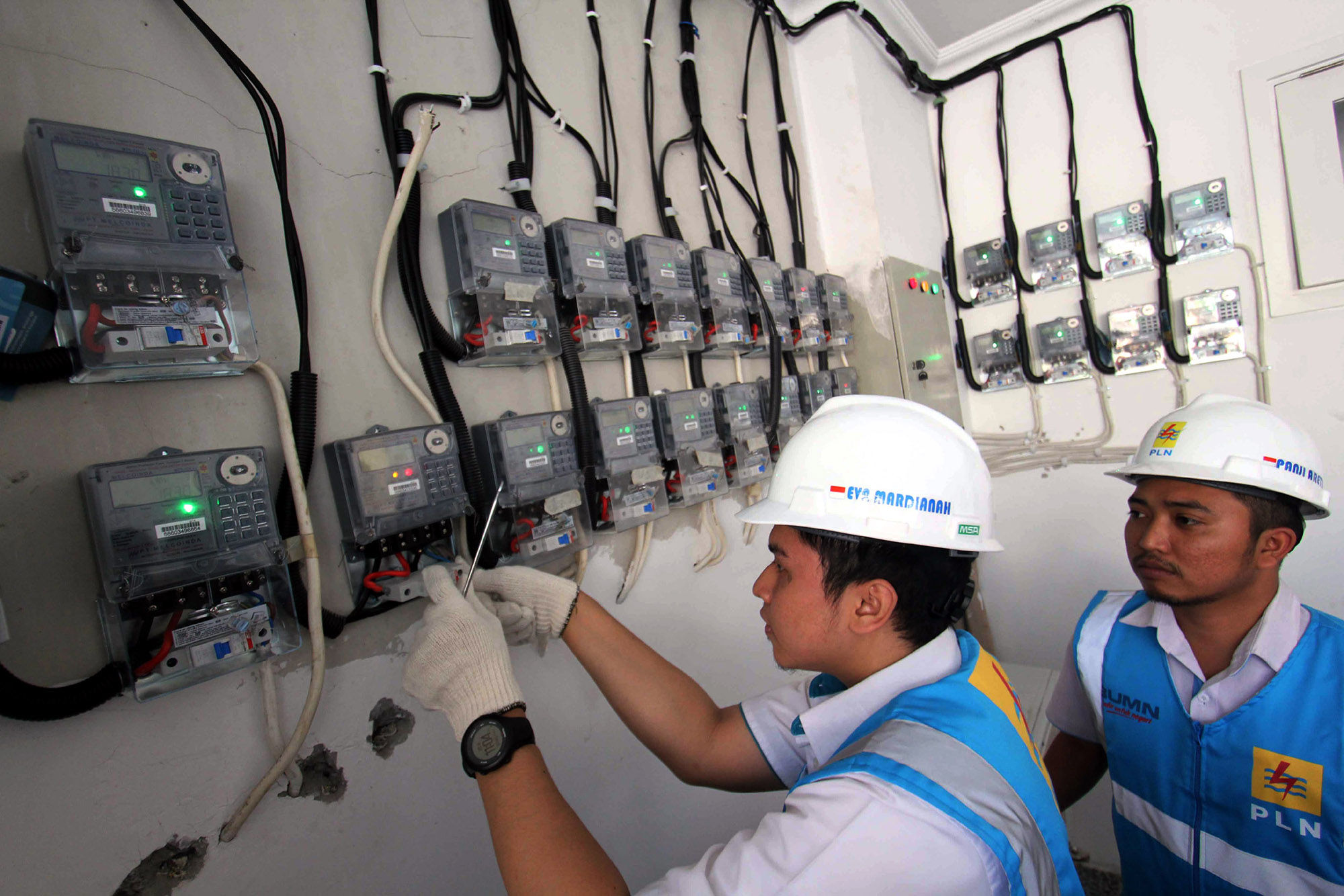 <p>Petugas PLN Area Bulungan Distribusi Jakarta Raya melakukan penyambungan penambahan daya pelanggan 1300 VA menjadi 2200 VA di kawasan Kebayoran Lama, Jakarta. Foto: Ismail Pohan/TrenAsia</p>
