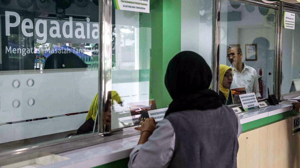 <p>Petugas melayani warga saat melakukan transaksi di gerai pegadaian Jakarta. Foto: Ismail Pohan/TrenAsia</p>
