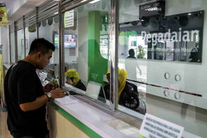 <p>Petugas melayani warga saat melakukan transaksi di gerai pegadaian Jakarta. Foto: Ismail Pohan/TrenAsia</p>
