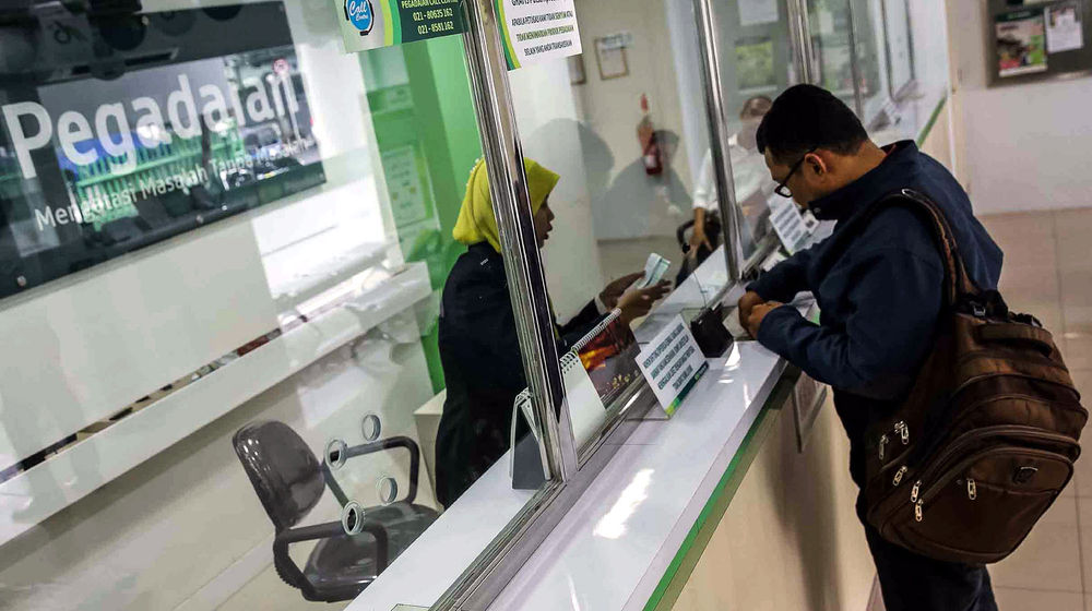 <p>Petugas melayani warga saat melakukan transaksi di gerai pegadaian Jakarta. Foto: Ismail Pohan/TrenAsia</p>
