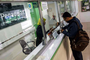 <p>Petugas melayani warga saat melakukan transaksi di gerai pegadaian Jakarta. Foto: Ismail Pohan/TrenAsia</p>
