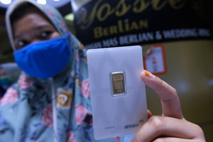 <p>Pramuniaga menunjukkan emas batangan di Cikini Gold Center, Jakarta, Rabu (8/4/2020). Harga emas 24 karat keluaran Logam Mulia PT Aneka Tambang Tbk (ANTM) turun Rp 17.000 per gram pada Rabu (8/4) berada di posisi Rp 946.000 per 1 Gram, setelah tembus rekor tertinggi sepanjang sejarah pada harga Rp 963.000 per 1 Gram pada Selasa (7/4). Foto: Ismail Pohan/TrenAsia</p>