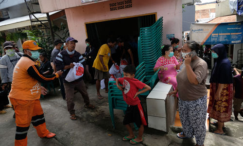 <p>Petugas menurunkan paket sembako dan makanan siap saji dari dalam truk untuk dibagikan kepada warga Kelurahan Kebon Baru, Tebet, Jakarta Selatan, Rabu (8/4/2020). Kementerian Sosial RI membagikan 200.000 paket sembako dan makanan siap saji kepada para warga terdampak virus Corona (COVID-19) di wilayah zona merah COVID-19 di DKI Jakarta. Pembagian paket sembako dan makanan siap saji ini dimaksudkan agar masyarakat menahan diri untuk tidak mudik yang dikhawatirkan berpotensi menyebarkan COVID-19 kepada lebih banyak orang. Foto: Ismail Pohan/Trenasia</p>
