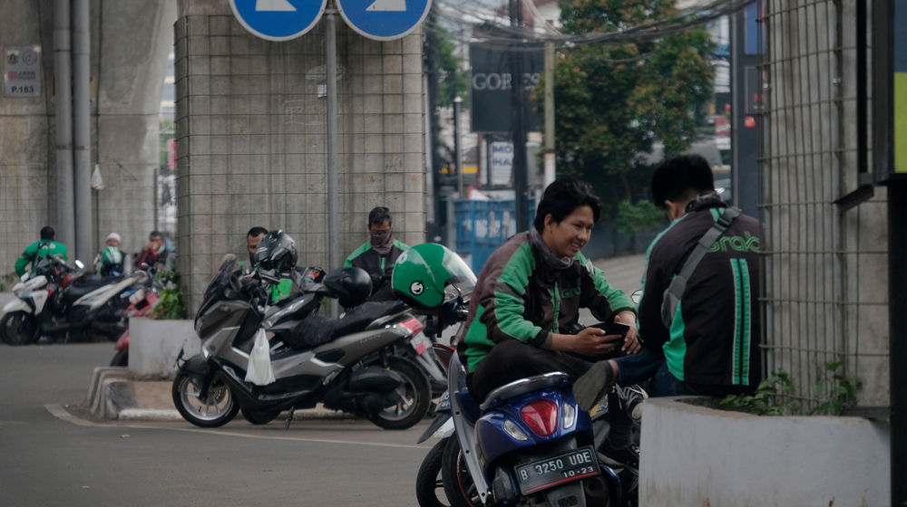 <p>Sejumlah Driver Ojek Online menunggu orderan di Jakarta, Jumat, 10 April 2020. Peraturan Gubernur DKI Jakarta dalam pelaksanaan PSBB mengatur angkutan roda dua seperti ojek online maupun ojek konvensional dilarang membawa penumpang. Foto: Ismail Pohan/TrenAsia</p>
