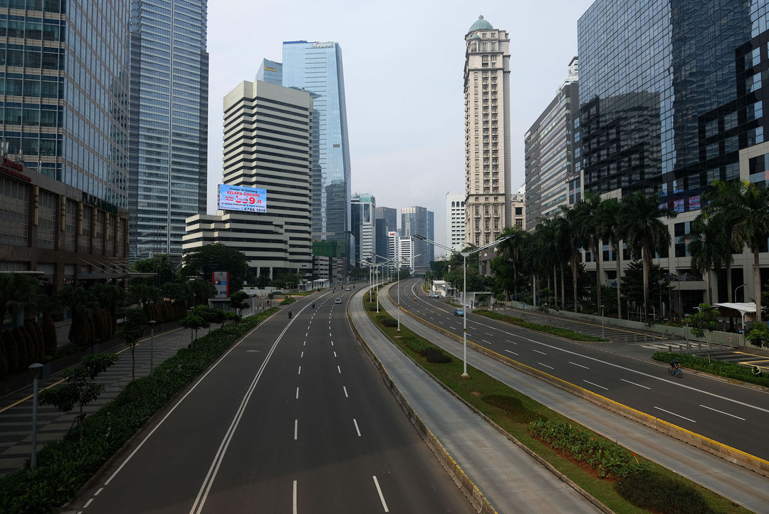 <p>Suasana lengang tampak di ruas Jalan Jenderal Sudirman, Jakarta Pusat, Jumat (10/4/2020). Pemprov DKI Jakarta mulai memberlakukan Pembatasan Sosial Berskala Besar (PSBB) selama 14 hari dimulai pada 10 April hingga 23 April 2020. Foto: Ismail Pohan/TrenAsia</p>
