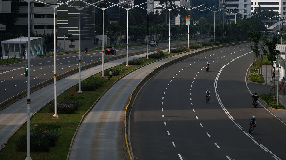 <p>Suasana lengang tampak di ruas Jalan Jenderal Sudirman, Jakarta Pusat, Jumat (10/4/2020). Pemprov DKI Jakarta mulai memberlakukan Pembatasan Sosial Berskala Besar (PSBB) selama 14 hari dimulai pada 10 April hingga 23 April 2020. Foto: Ismail Pohan/TrenAsia</p>
