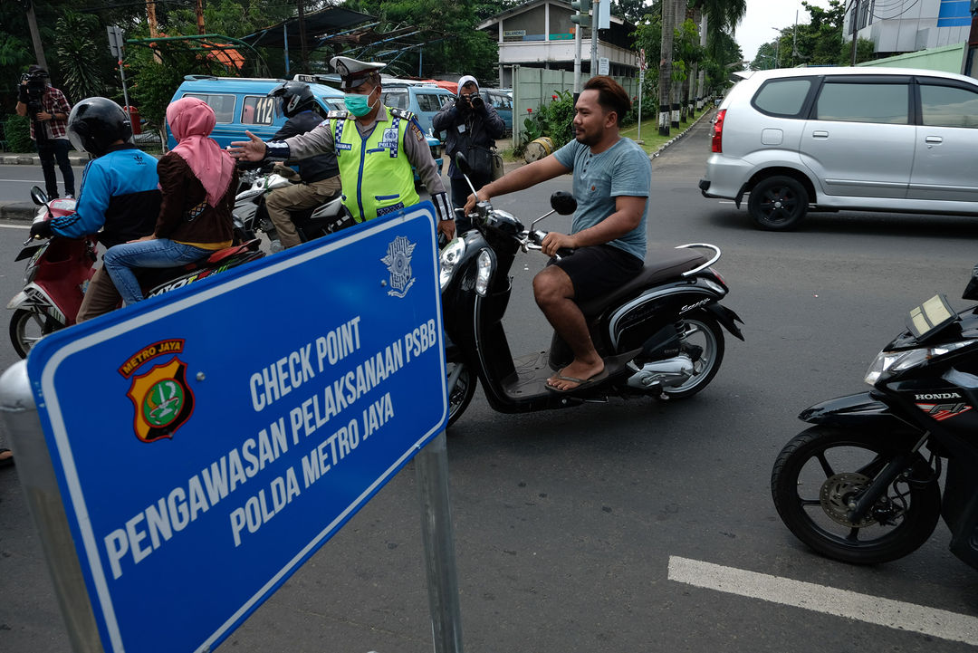 <p>Petugas Polantas bersama Dinas Perhubungan (Dishub) melaksanakan pengawasan dalam penerapan Pembatasan Sosial Berskala Besar (PSBB) di Jalan Raya Bogor perbatasan Depok-Jakarta, Jumat (10/4/2020). Petugas memberhentikan kendaraan untuk mengimbau kewajiban memakai masker dan aturan penumpang dalam satu kendaraan. Polisi pun mengingatkan warga jika tidak ada keperluan penting atau mendesak agar kembali ke rumah. Foto: Ismail Pohan/TrenAsia</p>
