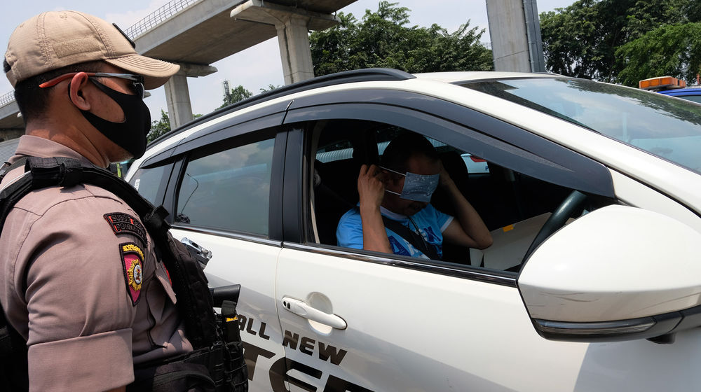 <p>Petugas Polantas bersama Dinas Perhubungan (Dishub) melaksanakan pengawasan dalam penerapan Pembatasan Sosial Berskala Besar (PSBB) di Jalan Raya Bogor perbatasan Depok-Jakarta, Jumat (10/4/2020). Petugas memberhentikan kendaraan untuk mengimbau kewajiban memakai masker dan aturan penumpang dalam satu kendaraan. Polisi pun mengingatkan warga jika tidak ada keperluan penting atau mendesak agar kembali ke rumah. Foto: Ismail Pohan/TrenAsia</p>