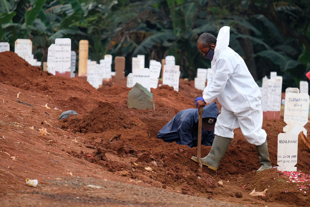 <p>Petugas Suku Dinas Pertamanan dan Pemakaman mengenakan perlengkapan APD menyiapkan liang kubur blok khusus kasus COVID-19 di Tempat Pemakaman Umum (TPU} Pondok Ranggon, Jakarta Timur, Minggu (26/4/2019). Untuk meminimalisir resiko dari banyaknya jumlah jenazah pasien COVID-19 yang dimakamkan setiap harinya, proses pemakaman berlangsung cepat dengan waktu paling lama sekitar 10 menit. Gubernur DKI Jakarta Anies Baswedan mengatakan, selama penerapan Pembatasan Sosial Berskala Besar (PSBB) tren pemakaman yang menggunakan prosedur tetap (protap) COVID-19 cenderung menurun. Foto: Ismail Pohan/TrenAsia</p>
