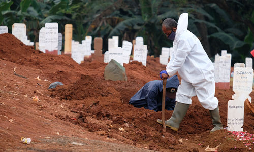 <p>Petugas Suku Dinas Pertamanan dan Pemakaman mengenakan perlengkapan APD menyiapkan liang kubur blok khusus kasus COVID-19 di Tempat Pemakaman Umum (TPU} Pondok Ranggon, Jakarta Timur, Minggu (26/4/2019). Untuk meminimalisir resiko dari banyaknya jumlah jenazah pasien COVID-19 yang dimakamkan setiap harinya, proses pemakaman berlangsung cepat dengan waktu paling lama sekitar 10 menit. Gubernur DKI Jakarta Anies Baswedan mengatakan, selama penerapan Pembatasan Sosial Berskala Besar (PSBB) tren pemakaman yang menggunakan prosedur tetap (protap) COVID-19 cenderung menurun. Foto: Ismail Pohan/TrenAsia</p>
