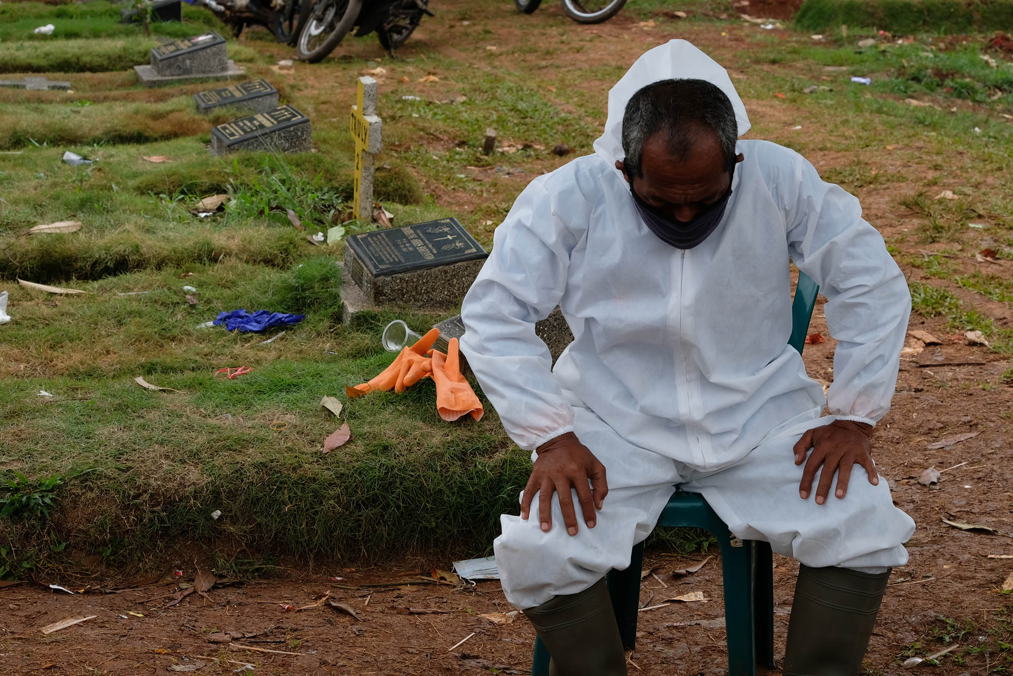 <p>Petugas Suku Dinas Pertamanan dan Pemakaman mengenakan perlengkapan APD beristirahat di area blok khusus kasus COVID-19 Tempat Pemakaman Umum (TPU} Pondok Ranggon, Jakarta Timur, Minggu (26/4/2019). Untuk meminimalisir resiko dari banyaknya jumlah jenazah pasien COVID-19 yang dimakamkan setiap harinya, proses pemakaman berlangsung cepat dengan waktu paling lama sekitar 10 menit. Foto: Ismail Pohan/TrenAsia</p>
