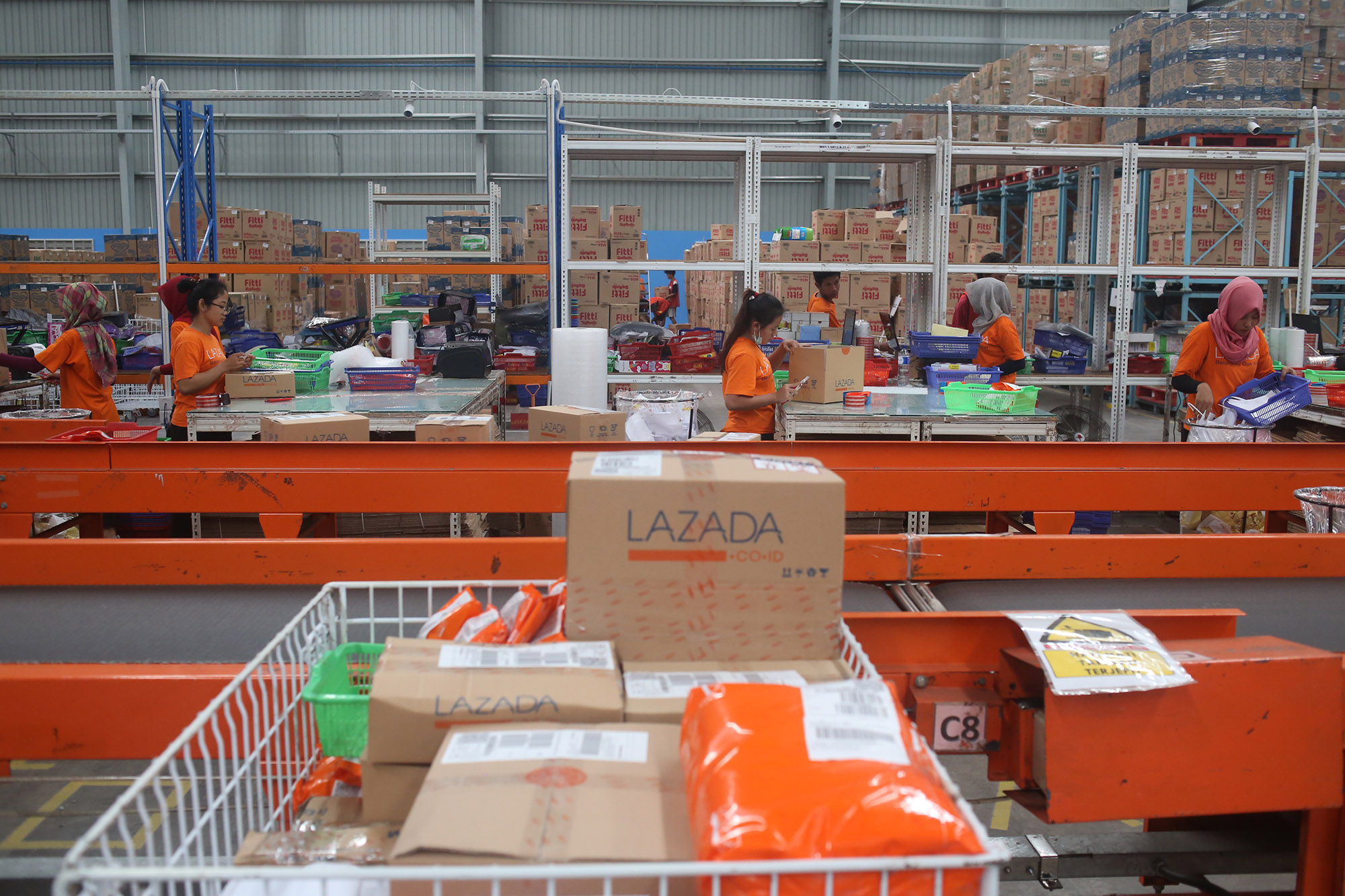 <p>Pekerja menyiapkan barang pesanan untuk dikirimkan kepada pembeli di gudang toko daring Lazada di Cimanggis, Depok, Jawa Barat. Foto: Ismail Pohan/TrenAsia</p>
