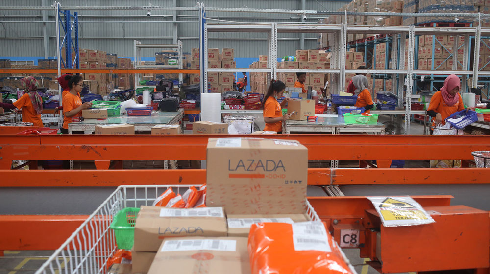 <p>Pekerja menyiapkan barang pesanan untuk dikirimkan kepada pembeli di gudang toko daring Lazada di Cimanggis, Depok, Jawa Barat. Foto: Ismail Pohan/TrenAsia</p>
