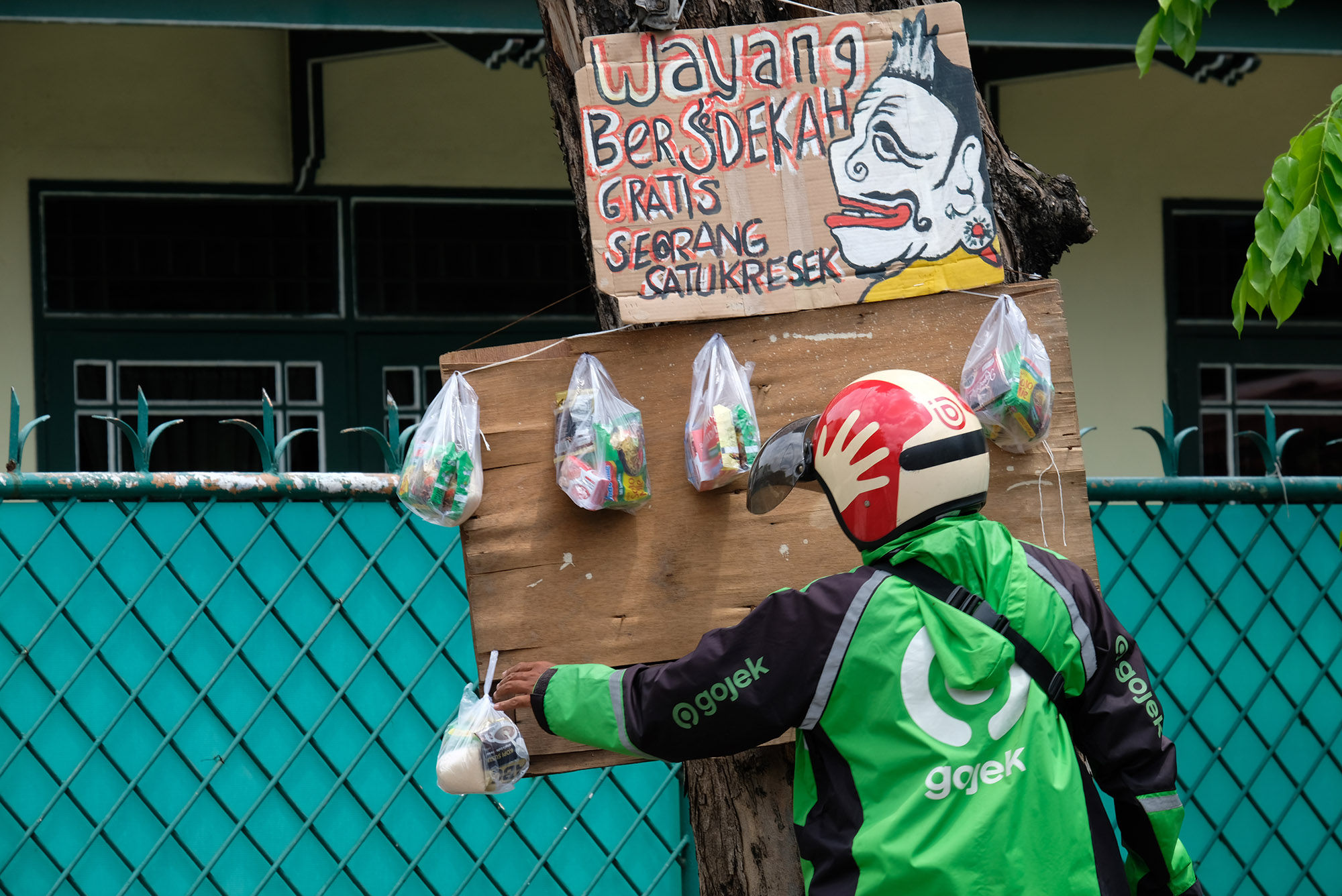 <p>Driver ojek online mengambil paket bahan makanan yang digantung di batang pohon di Jalan Cawang Baru Utara, Jakarta Timur, Kamis (16/4/2020). Aksi bertajuk &#8220;Wayang Bersedekah&#8221; ini merupakan inisiatif Iskandar dalam menanggapi kondisi pandemi corona. Bahan makanan yang dibagikan kepada warga di dapat dari hasil penjualan wayang berbahan sampah daur ulang. Dalam sehari rata-rata sebanyak 20 [&hellip;]</p>
