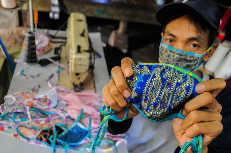 <p>Pekerja menunjukkan masker kain produksi penjahit konveksi di Kampung Cibangkur, Lebak, Banten, Senin (6/4/2020). Tingginya permintaan masker membuat penjahit konveksi di daerah tersebut dapat memproduksi 500-1000 lembar masker kain per hari dengan harga Rp5.000 per lembarnya, dan dipasarkan ke sejumlah kota seperti Serang, Cilegon, Tangerang, dan Jakarta. ANTARA FOTO/Muhammad Bagus Khoirunas/hp.</p>
