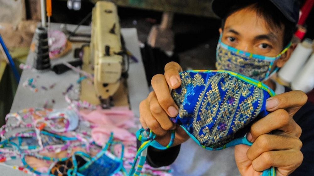 <p>Pekerja menunjukkan masker kain produksi penjahit konveksi di Kampung Cibangkur, Lebak, Banten, Senin (6/4/2020). Tingginya permintaan masker membuat penjahit konveksi di daerah tersebut dapat memproduksi 500-1000 lembar masker kain per hari dengan harga Rp5.000 per lembarnya, dan dipasarkan ke sejumlah kota seperti Serang, Cilegon, Tangerang, dan Jakarta. ANTARA FOTO/Muhammad Bagus Khoirunas/hp.</p>
