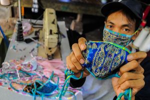 <p>Pekerja menunjukkan masker kain produksi penjahit konveksi di Kampung Cibangkur, Lebak, Banten, Senin (6/4/2020). Tingginya permintaan masker membuat penjahit konveksi di daerah tersebut dapat memproduksi 500-1000 lembar masker kain per hari dengan harga Rp5.000 per lembarnya, dan dipasarkan ke sejumlah kota seperti Serang, Cilegon, Tangerang, dan Jakarta. ANTARA FOTO/Muhammad Bagus Khoirunas/hp.</p>
