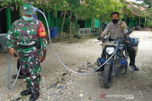 <p>Bripka Fakhrin Ilham bersama Babinsa melakukan penyemprotan disinfektan ke lingkungan sekolah menggunakan motor Bhabinkamtibmas yang telah dimodifikasi. /Antara</p>
