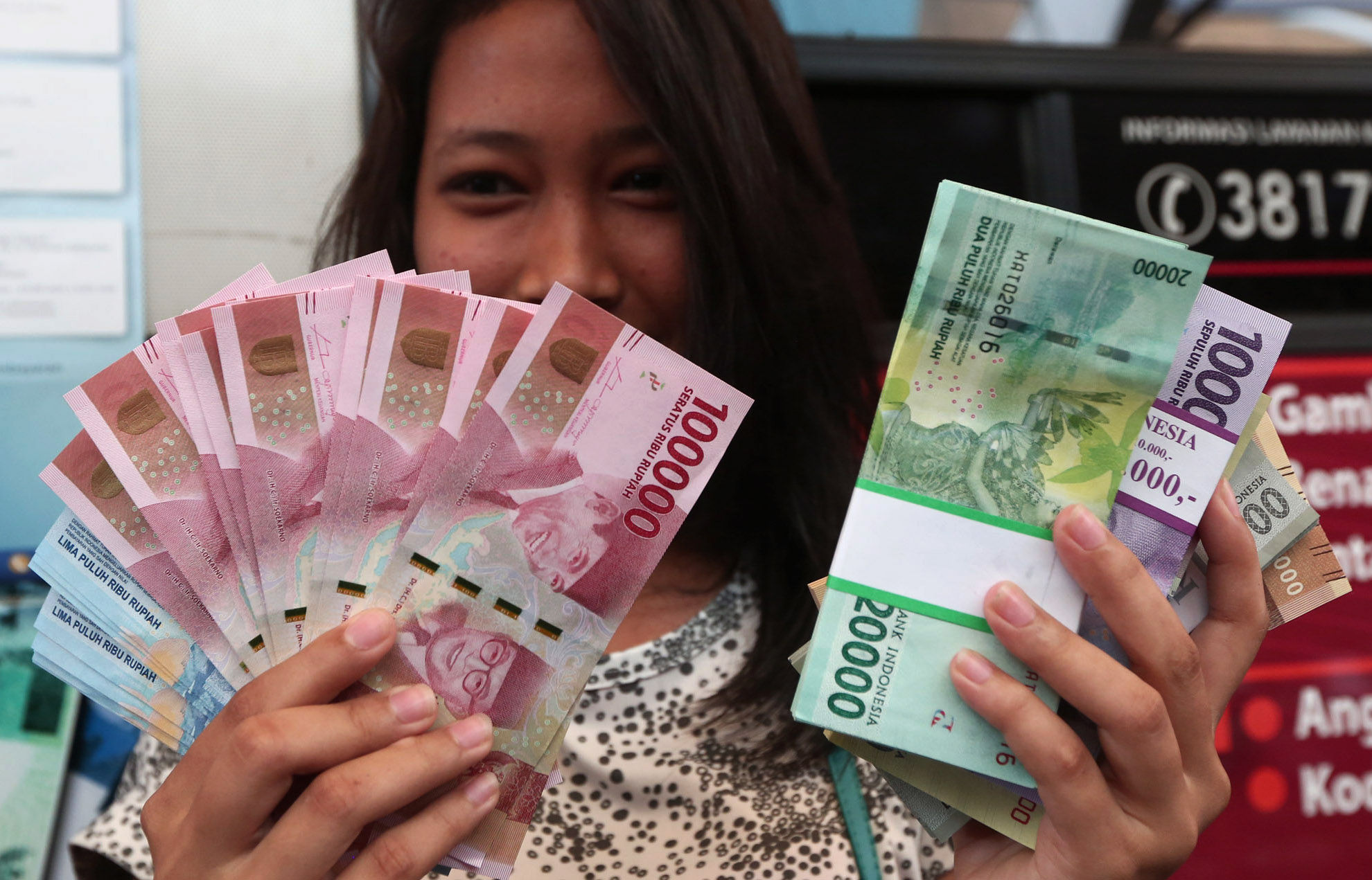 <p>Warga menunjukkan uang kertas rupiah baru tahun emisi 2016 usai melakukan penukaran di pusat perbelanjaan di Jakarta, Senin (19/12). Foto: Ismail Pohan/TrenAsia</p>
