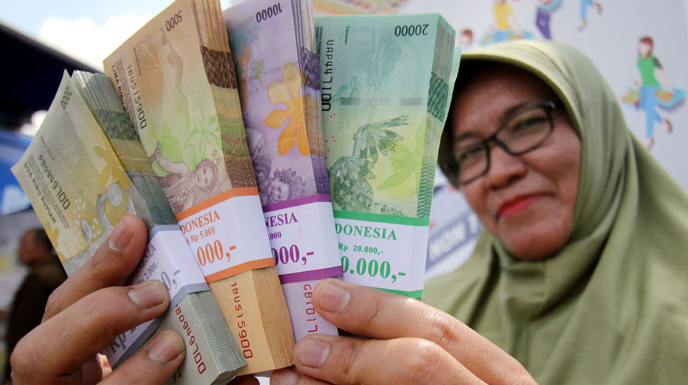 <p>Warga menunjukan uang pecahan yang telah di tukarkan di Lapangan IRTI Monas, Jakarta. Foto: Ismail Pohan/TrenAsia</p>
