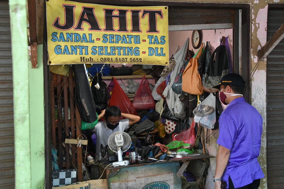 petugas sedang memberikan arahan tentang protokol kesehatan di pasar tradisional
