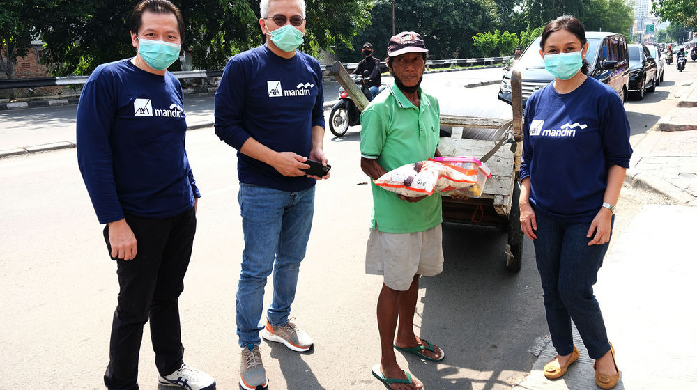 <p>Presiden Direktur AXA Mandiri Handojo G Kusuma (kiri) bersama Direktur Kepatuhan AXA Mandiri Rudy Kamdani (kedua kiri) dan Chief of Human Capital AXA Mandiri Elisabeth Dewi Evaty (kanan) membagikan paket sembako kepada warga terdampak Covid-19 di wilayah Jabodetabek. Sebanyak total 2.000 paket Sembako disalurkan untuk masyarakat terdampak Covid-19 oleh karyawan AXA Mandiri sebagai peran aktif terhadap kegiatan Mandirian Cinta Indonesia, yaitu program bantuan bersama grup usaha yang tergabung dalam Mandiri Group. Kegiatan ini juga bagian dari rangkaian kepedulian perusahaan untuk menyalurkan donasi berupa paket sembako, vitamin dan alat pelindung diri (APD) bagi masyarakat terdampak pandemi, serta rumah sakit yang membutuhkan. Foto: Ismail Pohan/TrenAsia</p>