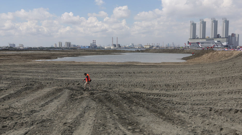 <p>Pekerja melintas di salah satu lokasi reklamasi Teluk Jakarta di Pulau G, Jakarta. Foto: Ismail Pohan/TrenAsia</p>