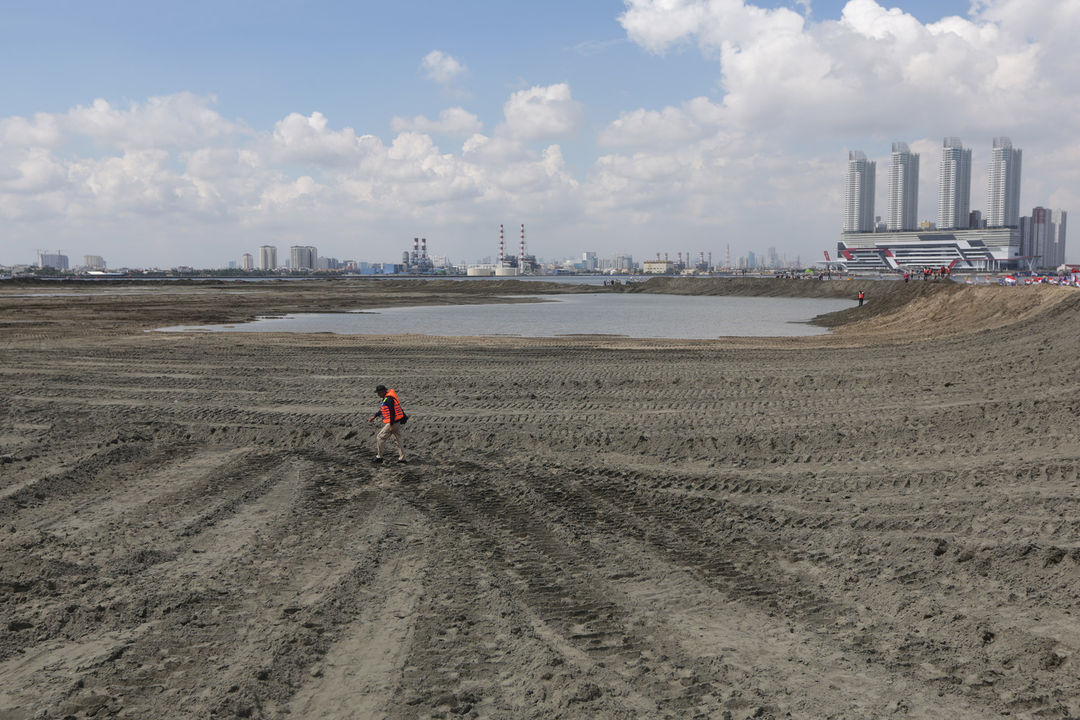 <p>Pekerja melintas di salah satu lokasi reklamasi Teluk Jakarta di Pulau G, Jakarta.  Foto: Ismail Pohan/TrenAsia</p>
